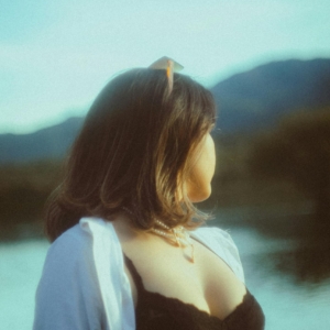 Woman in an Unbuttoned Blouse Looking Around at the Lake