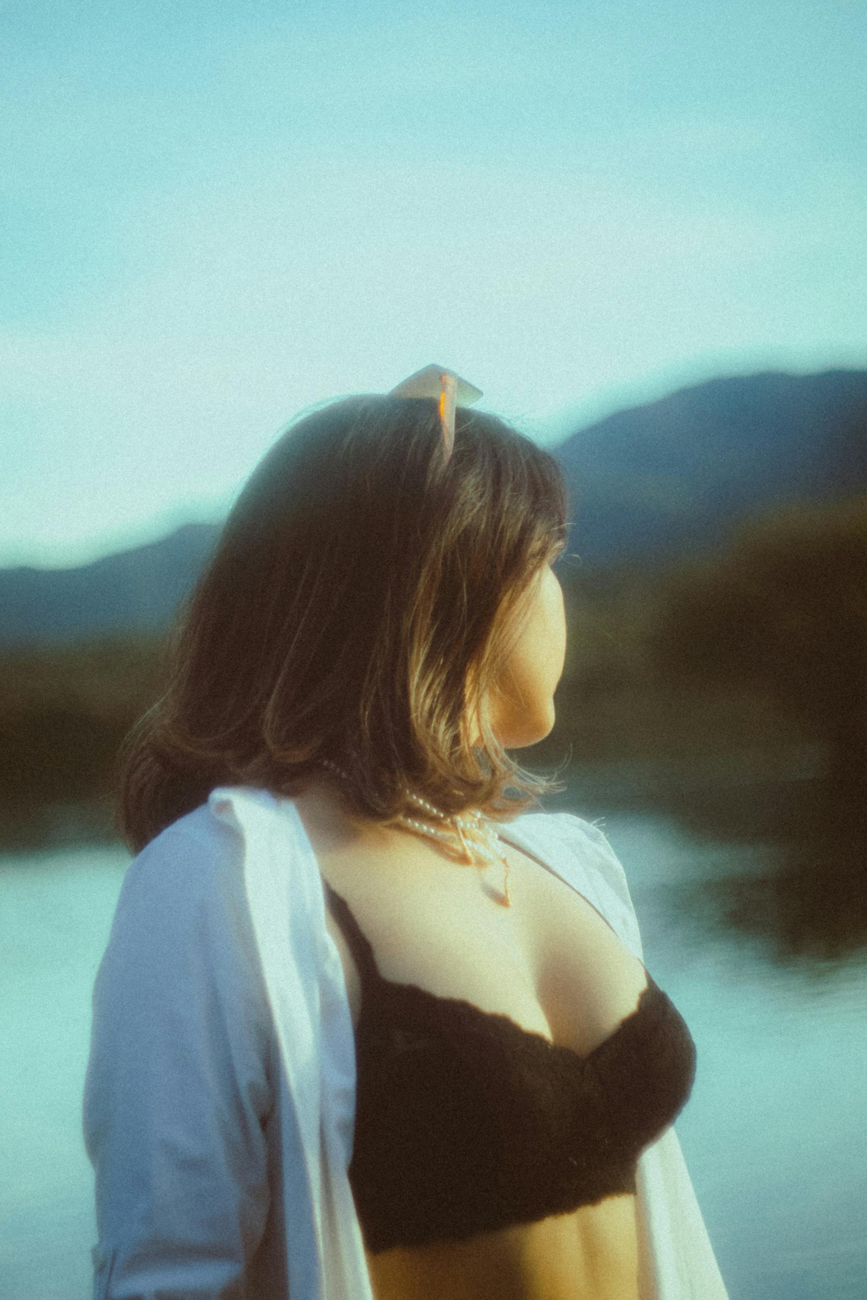 Woman in an Unbuttoned Blouse Looking Around at the Lake