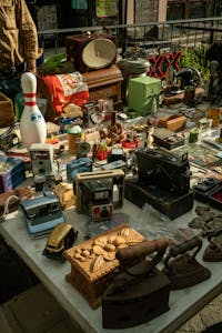 A variety of vintage items including cameras, radios, and toys displayed at a flea market stall in Aguascalientes, Mexico.